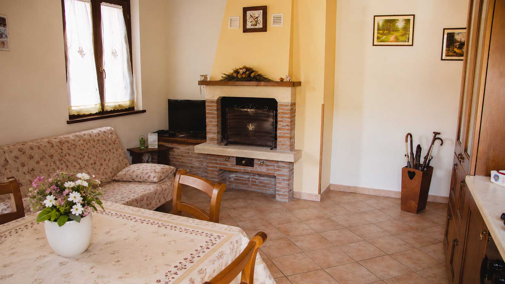 Accogliente soggiorno rustico con camino, ideale per i turisti italiani in cerca di relax in un agriturismo umbro.