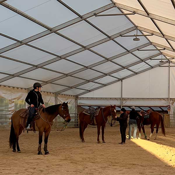 Lezione di equitazione al coperto in un agriturismo umbro, perfetta per esplorare la natura a cavallo.