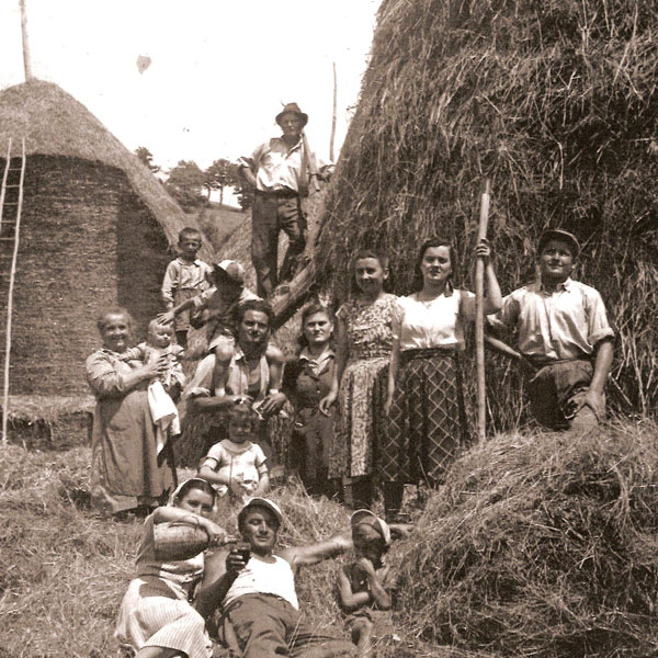 Gruppo di contadini umbri nei campi, simbolo dell'autentica vita rurale da scoprire in agriturismo.