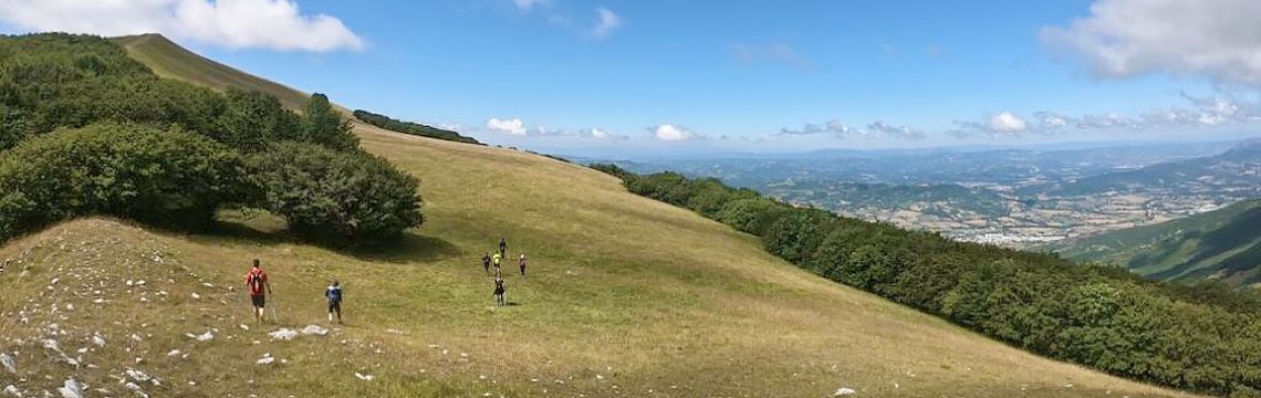 Turisti in escursione sui verdi colli umbri, immersi nella natura e con vista panoramica sullo splendido paesaggio regionale.